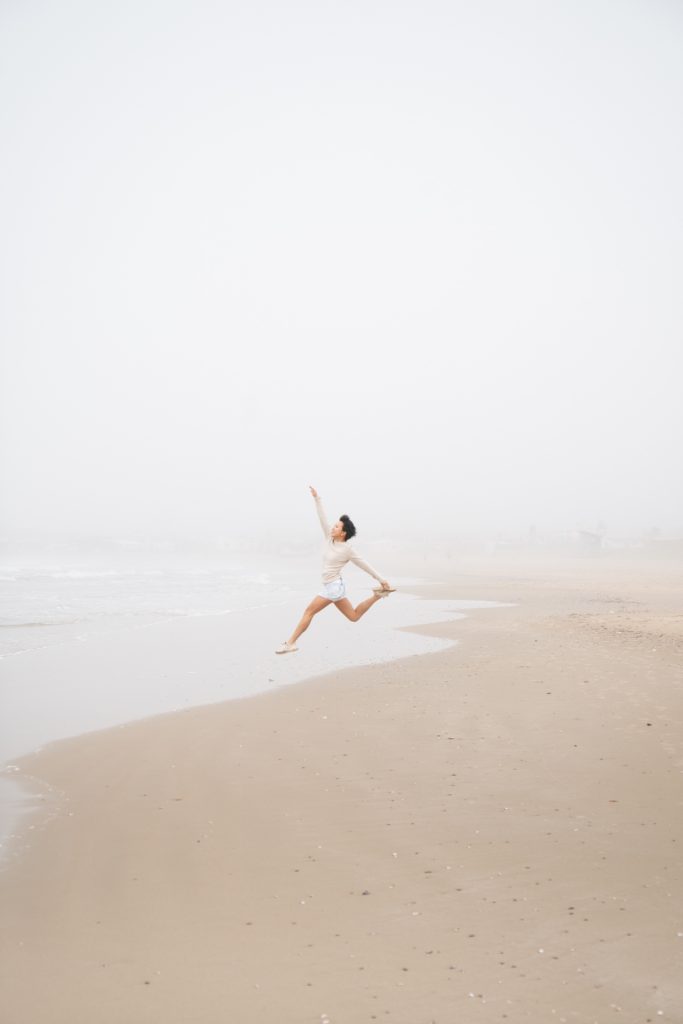 Girl jumps into air on the beach