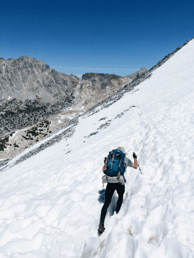 Man uses trekking poles to cross glen pass snow