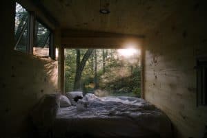 Person illuminated by morning sun in wooden cabin