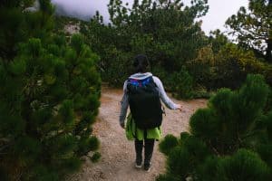 Woman walks among trees on hike to Nevado de Colima