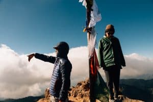 Guide and hiker stand at top of Nevado de Colima