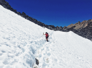 Female hiker crossing snow in Glen Pass