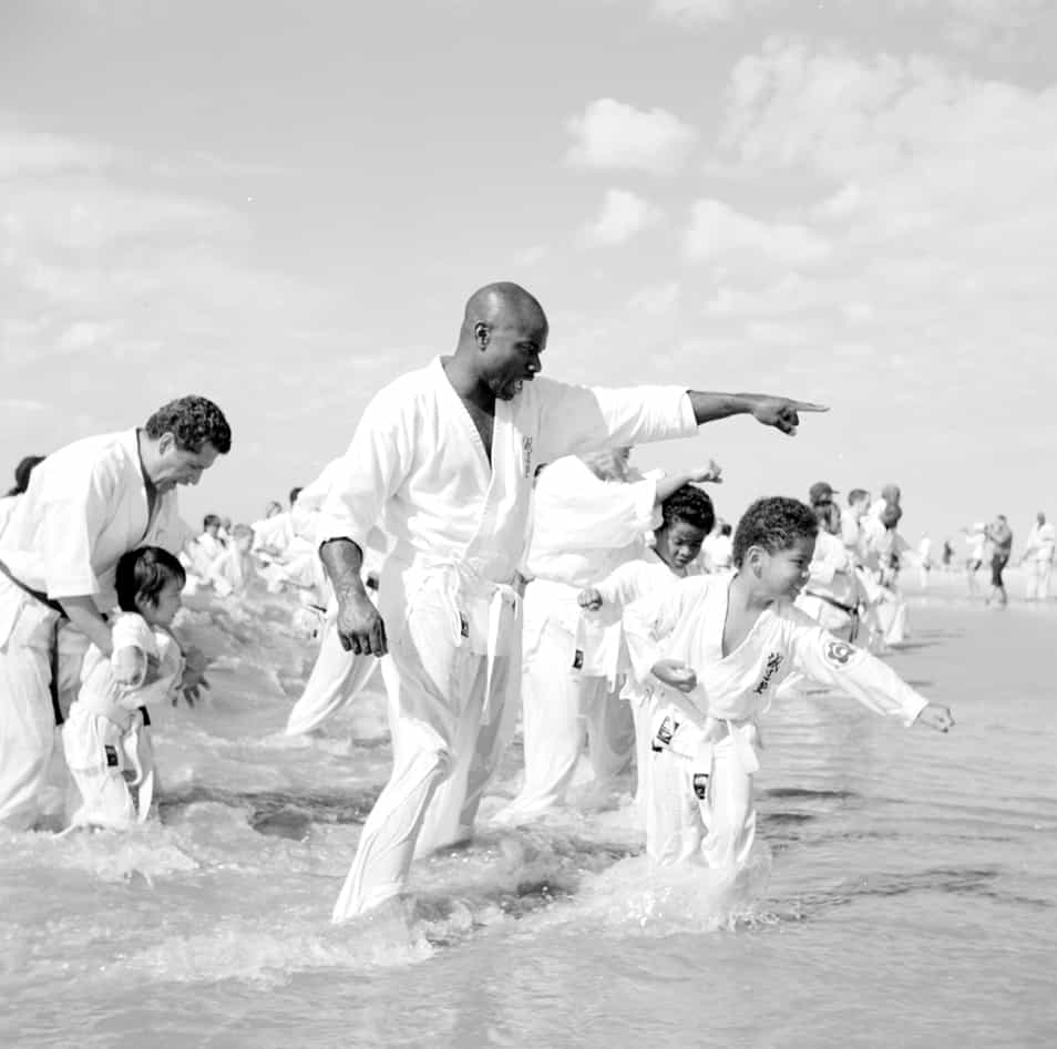 Karate teachers instruct their young students in the receding waves of Coney Island's beach