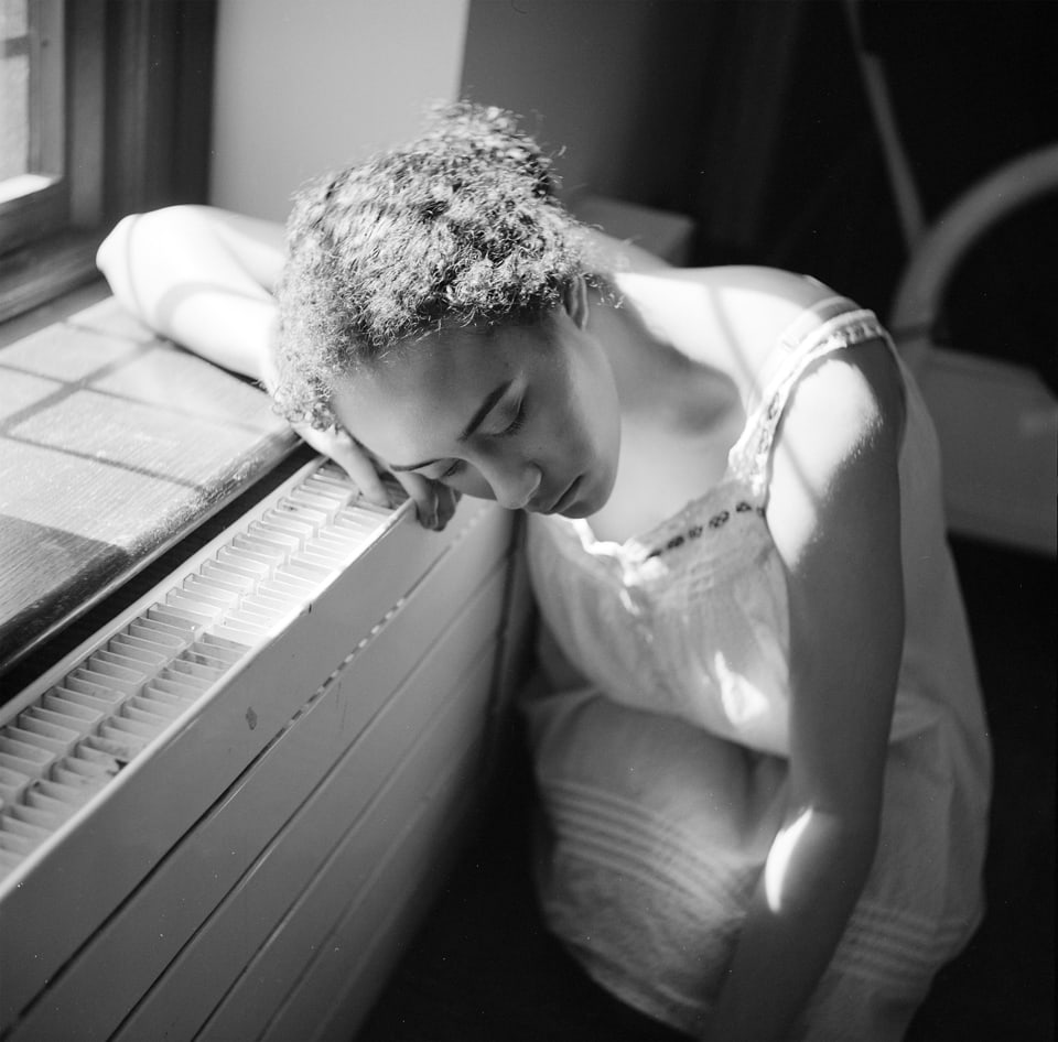 Portrait of woman resting her head near the window